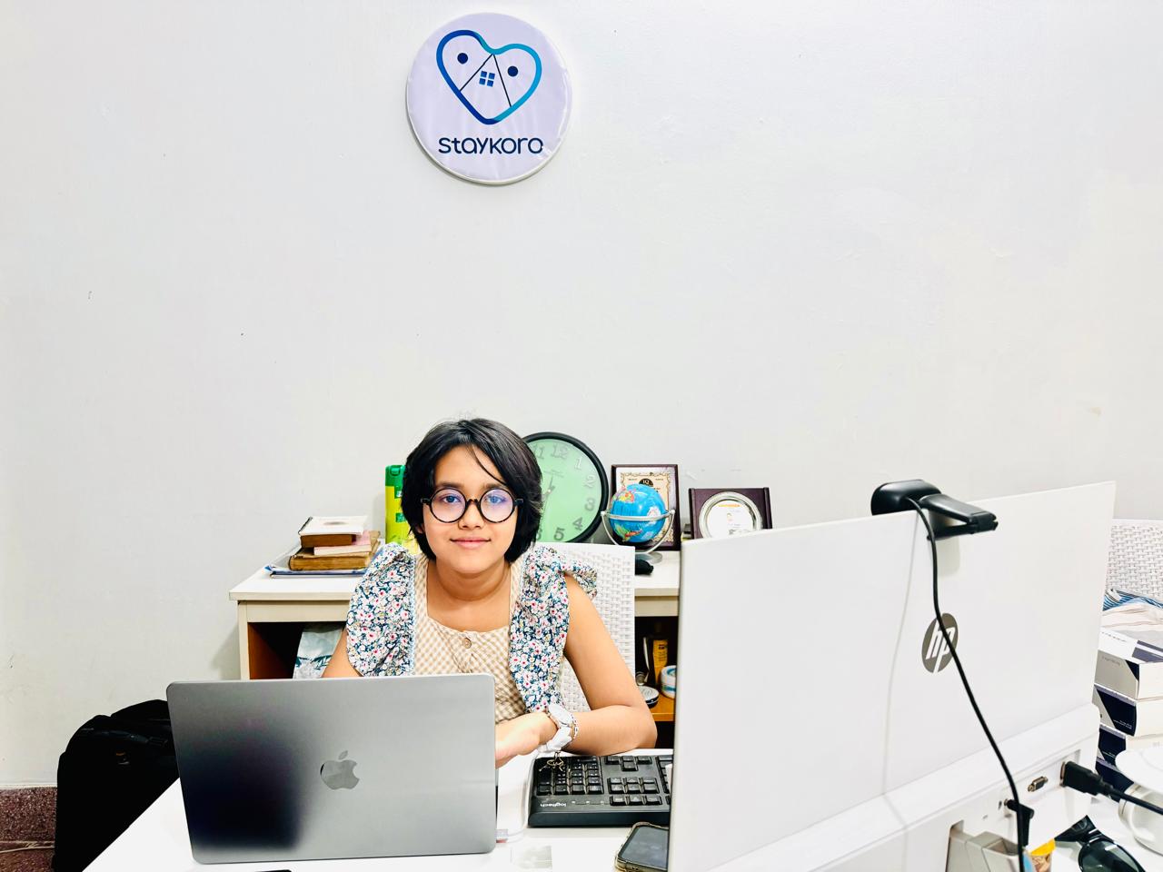 Drisana working on her laptop at a desk with study materials
